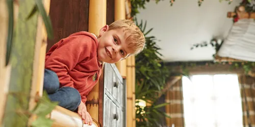 Child peeking round a corner inside a Penguin themed room