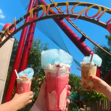 Three people holding up their Freakshakes from Dragon's Delights at Chessington World of Adventures Resort