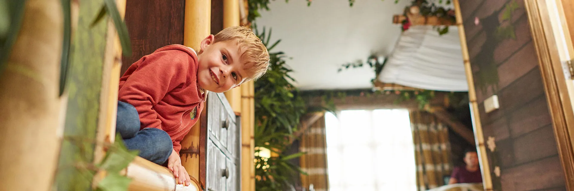 Child peeking round a corner inside a Penguin themed room