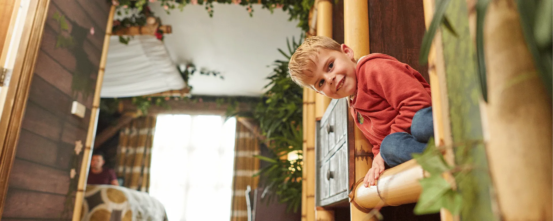 Child peeking round a corner inside a Penguin themed room